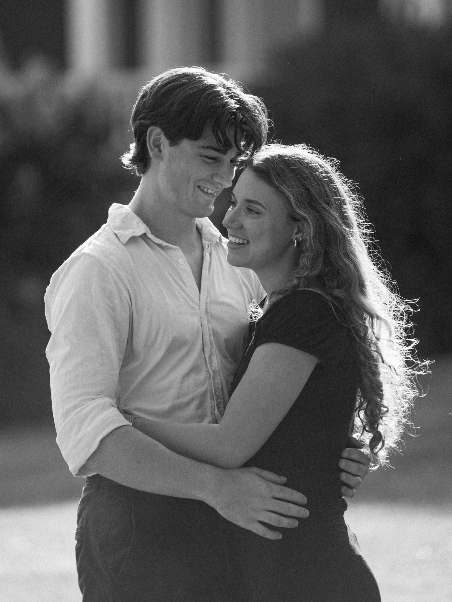 Intimate black and white portrait showing tender embrace outdoors.