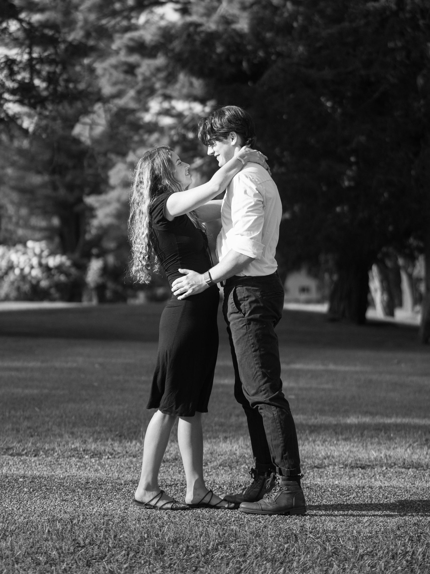 Black and white photo series showing playful moments between a couple in a park.