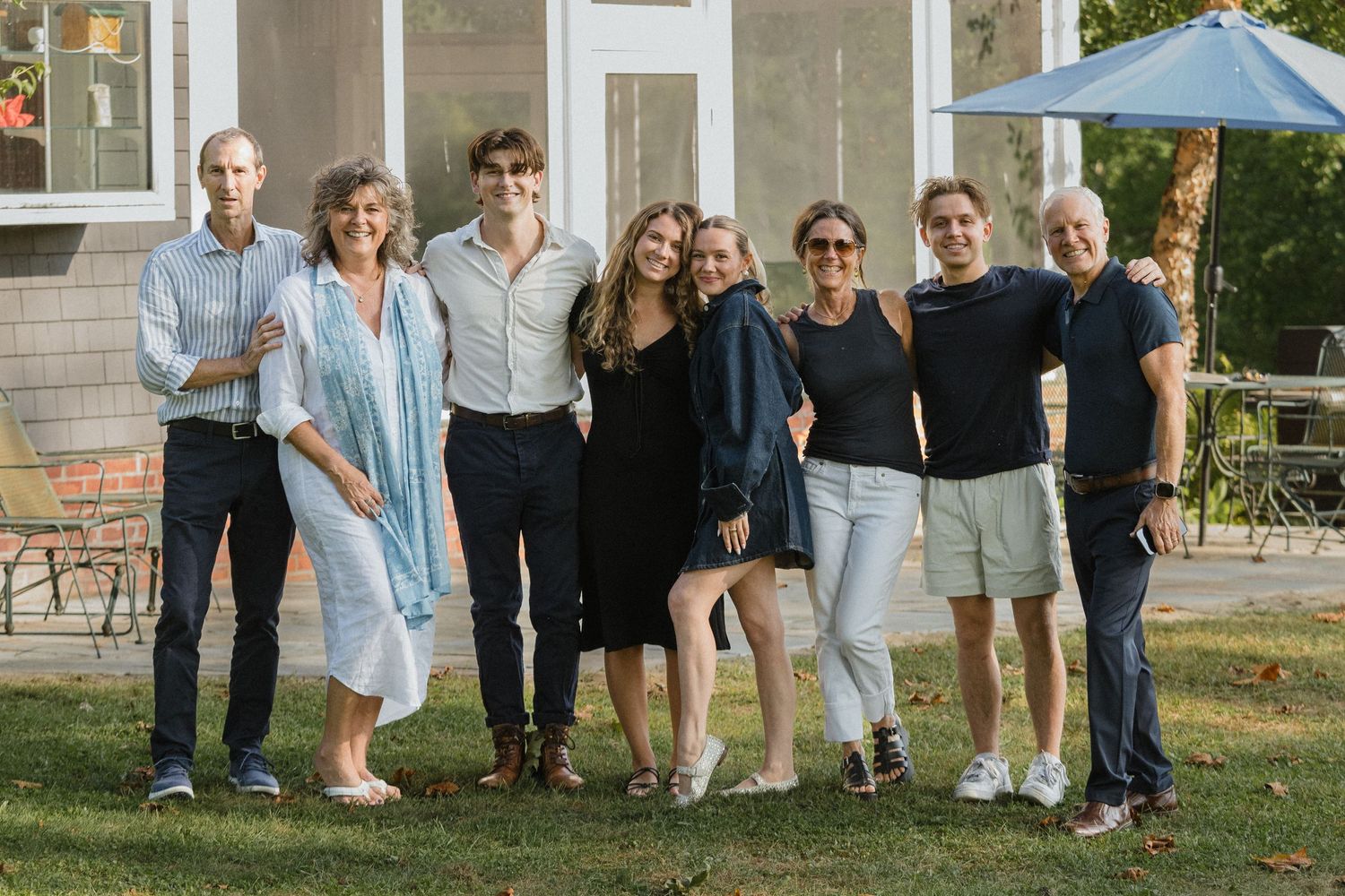 Large group photo of people gathered outside a house.
