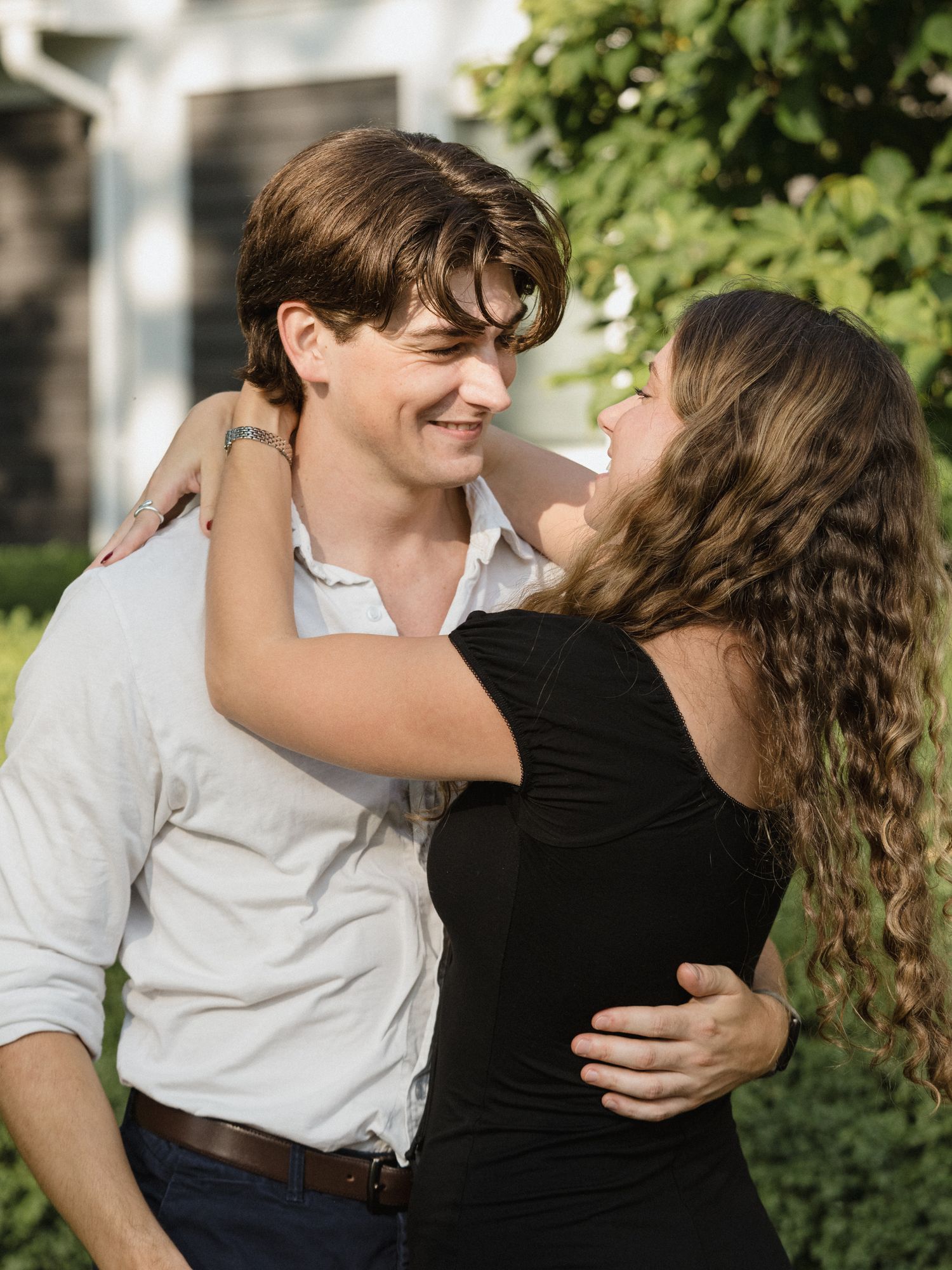 A romantic moment shared between a couple in casual attire outdoors.