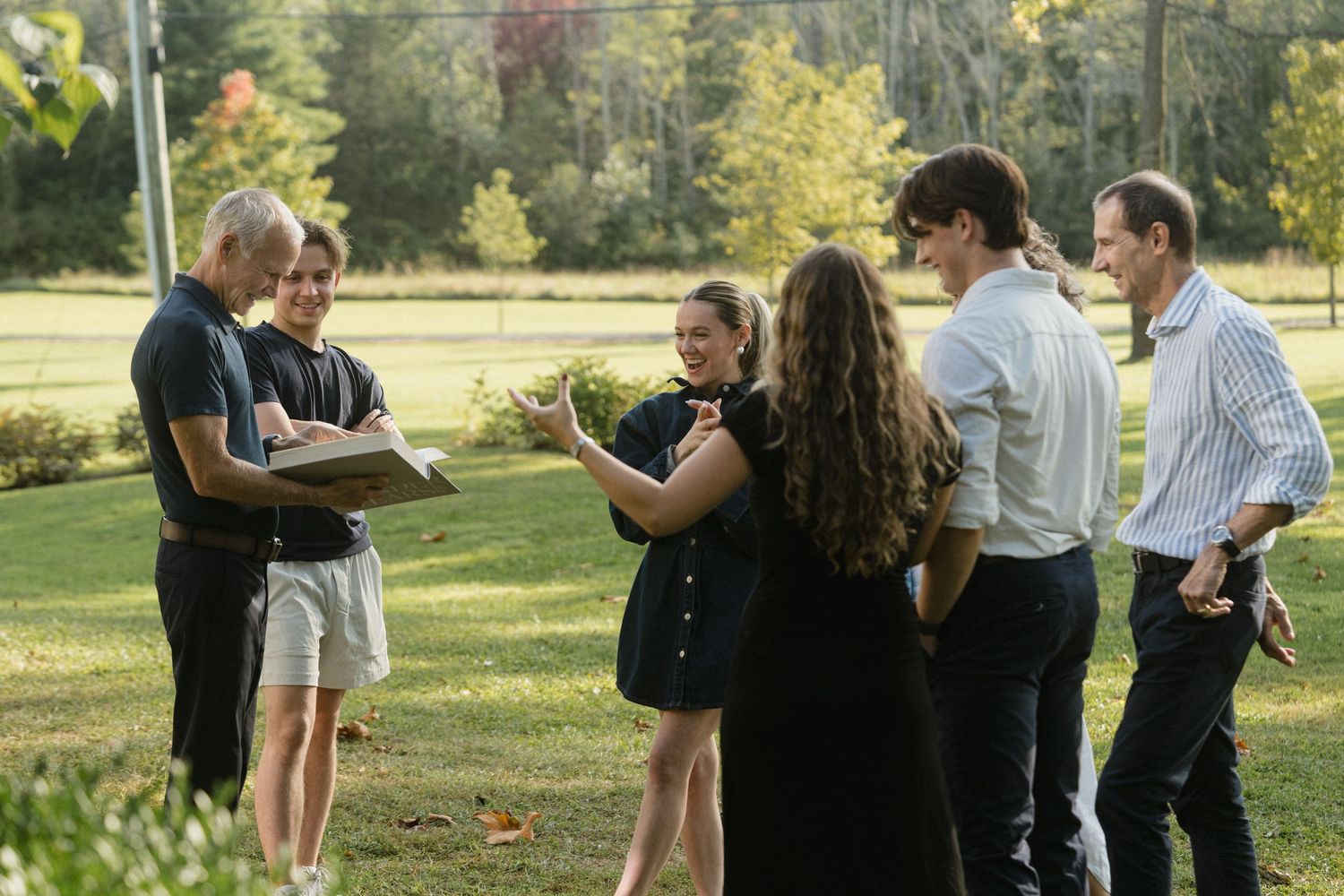 A small group gathered outdoors on a sunny day discussing together.