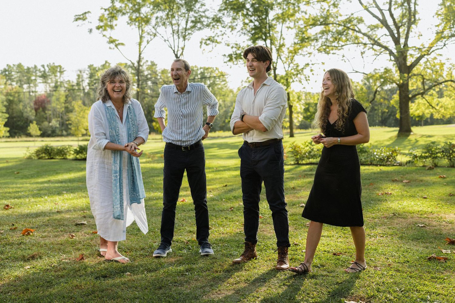 A small group having an outdoor discussion on a sunny lawn.
