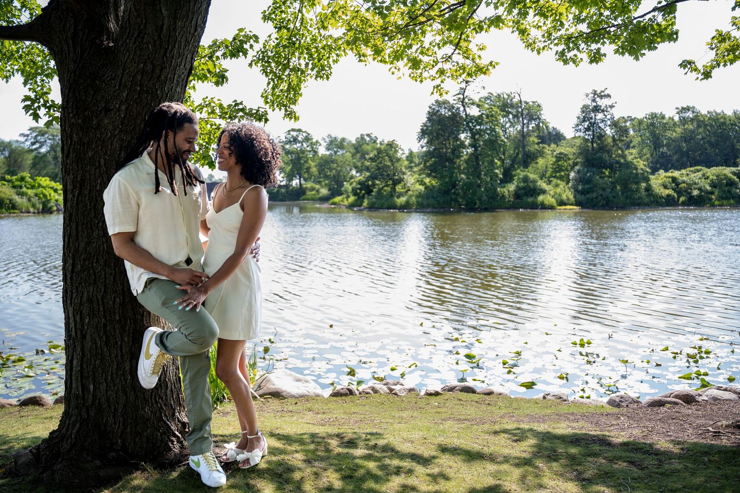 A romantic lakeside engagement photo session shows a couple sharing intimate moments along a tranquil waterfront.