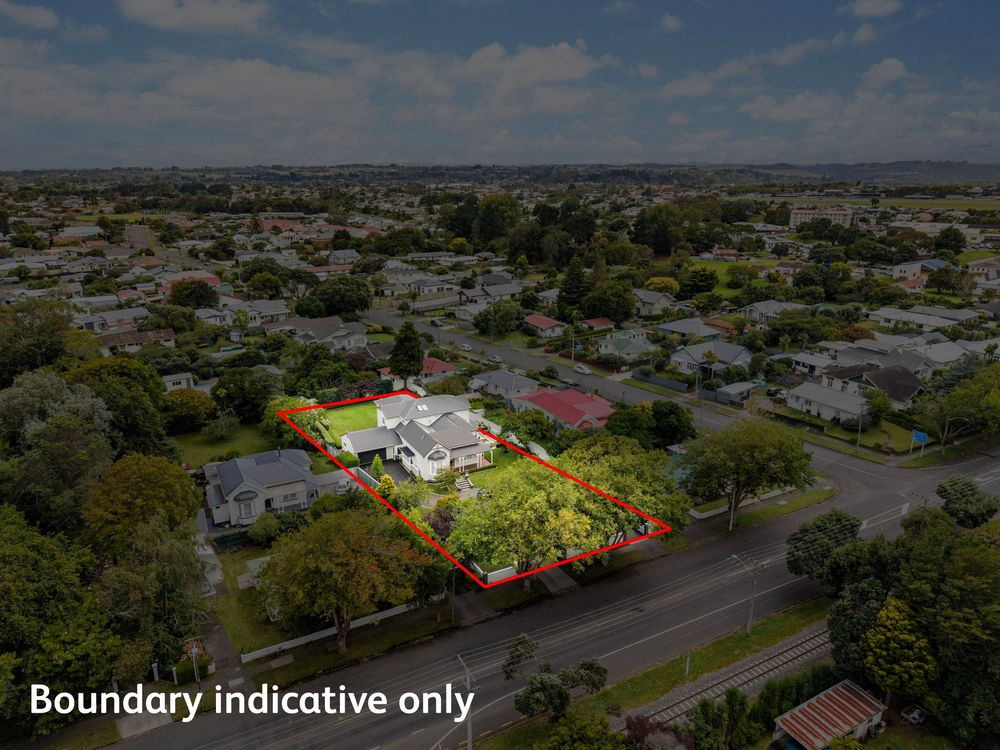 Aerial view of a residential property with boundary marked in red, surrounded by mature trees in a suburban neighborhood.