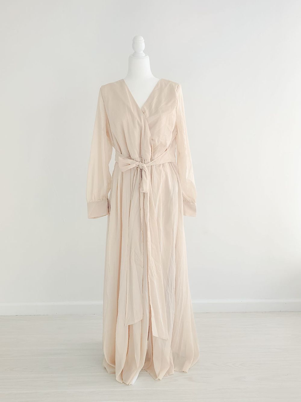 Pale pink empire waist dress with v-neck and flowing skirt shown on mannequin from multiple angles.