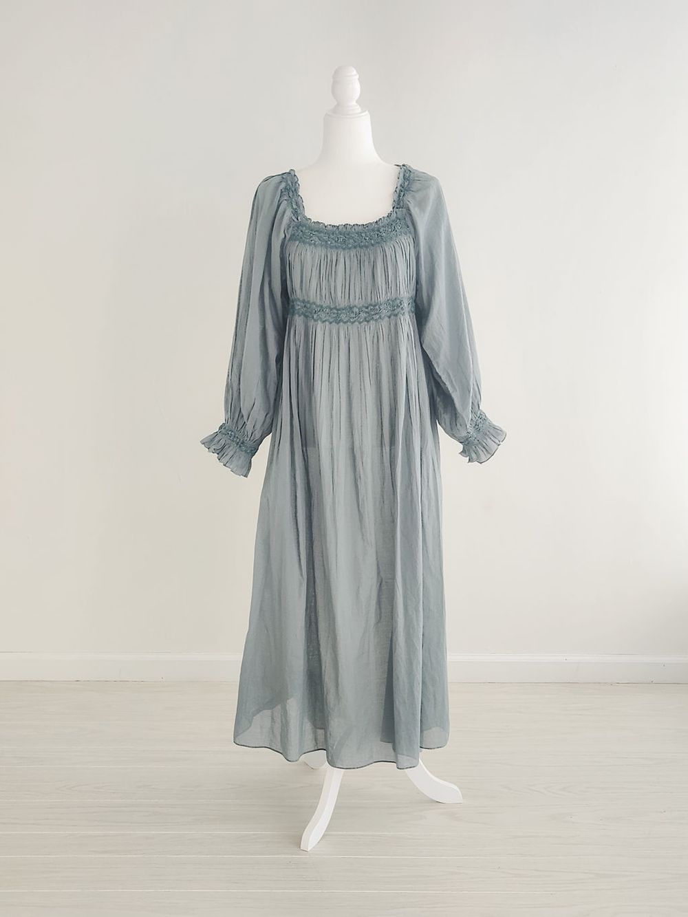 Light blue-gray peasant dress with ruffled sleeves and gathered neckline displayed on mannequin in various views.