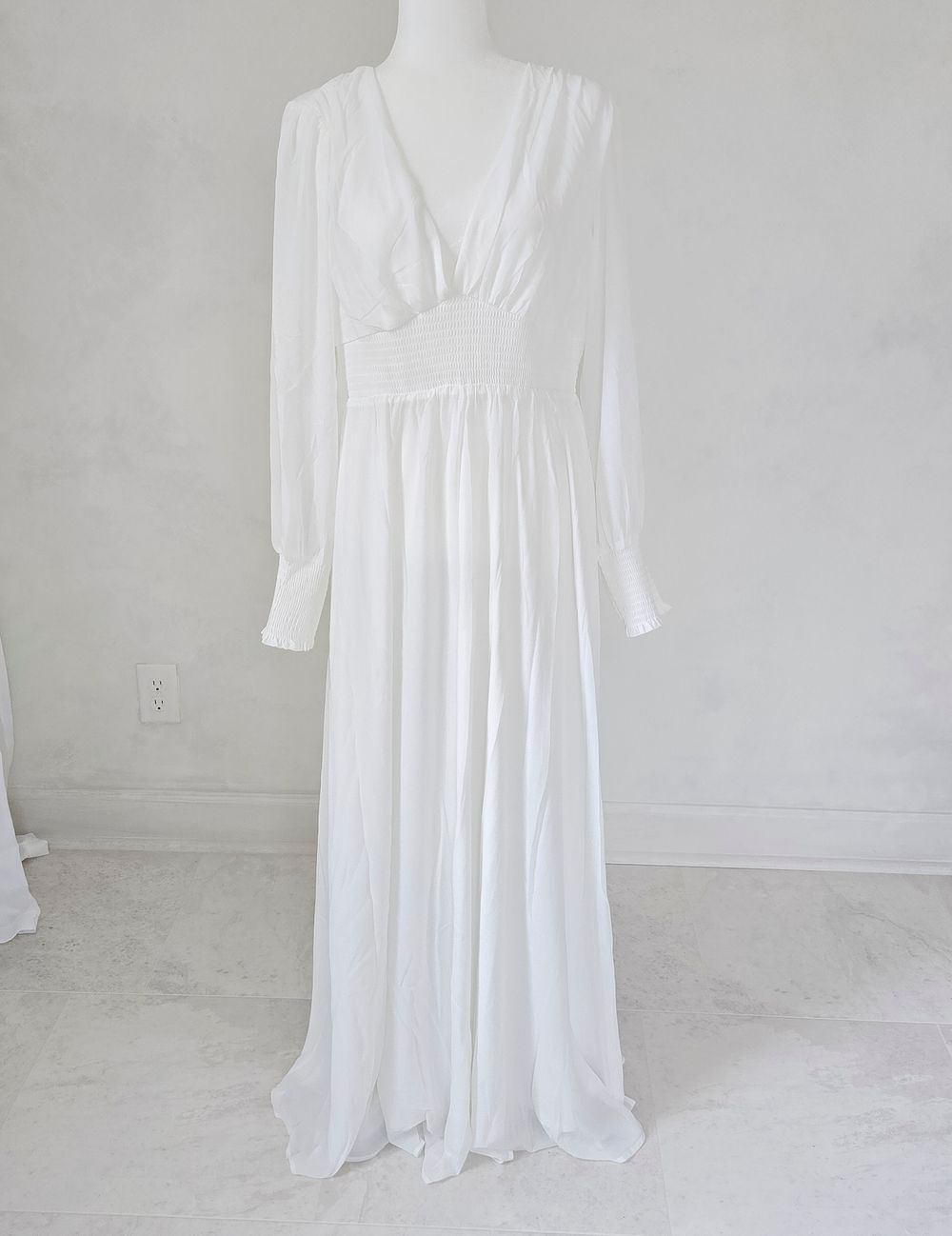 A white empire waist dress with long sleeves shown from multiple angles on a light gray background.