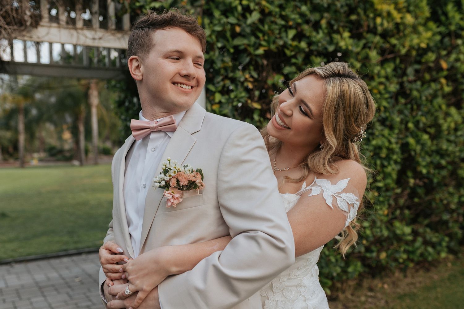 A joyful moment captured at a wedding showing romantic embraces and laughter in an outdoor garden setting at Singing Hills Golf Resort.