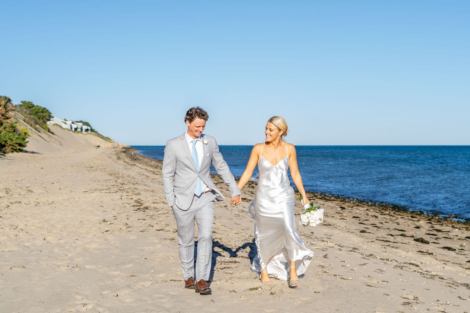 Couple walking on the beach during their wedding portraits on Cape Cod, Massachusetts.