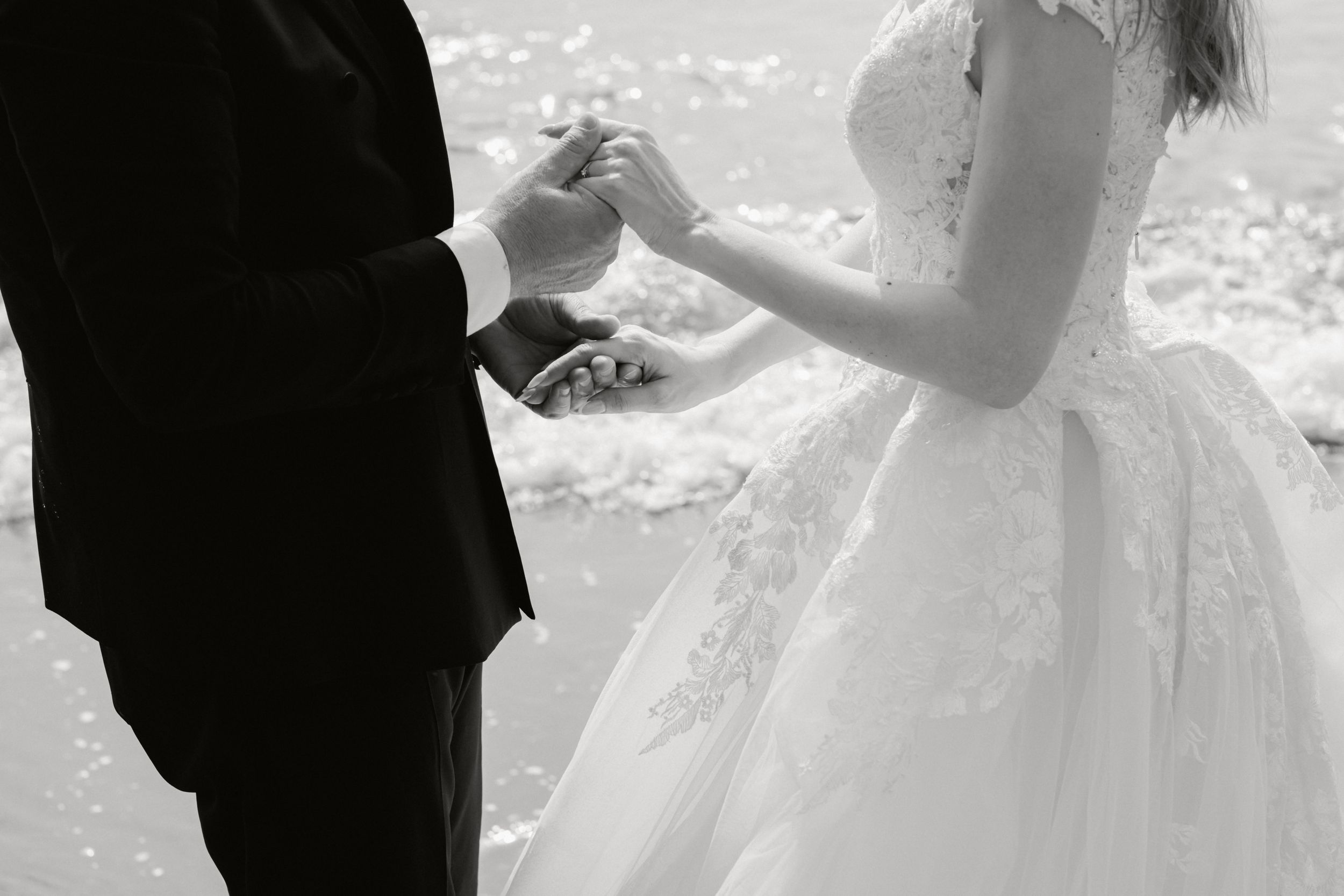 A couple shares a romantic first dance at their wedding reception while guests look on and take photos.