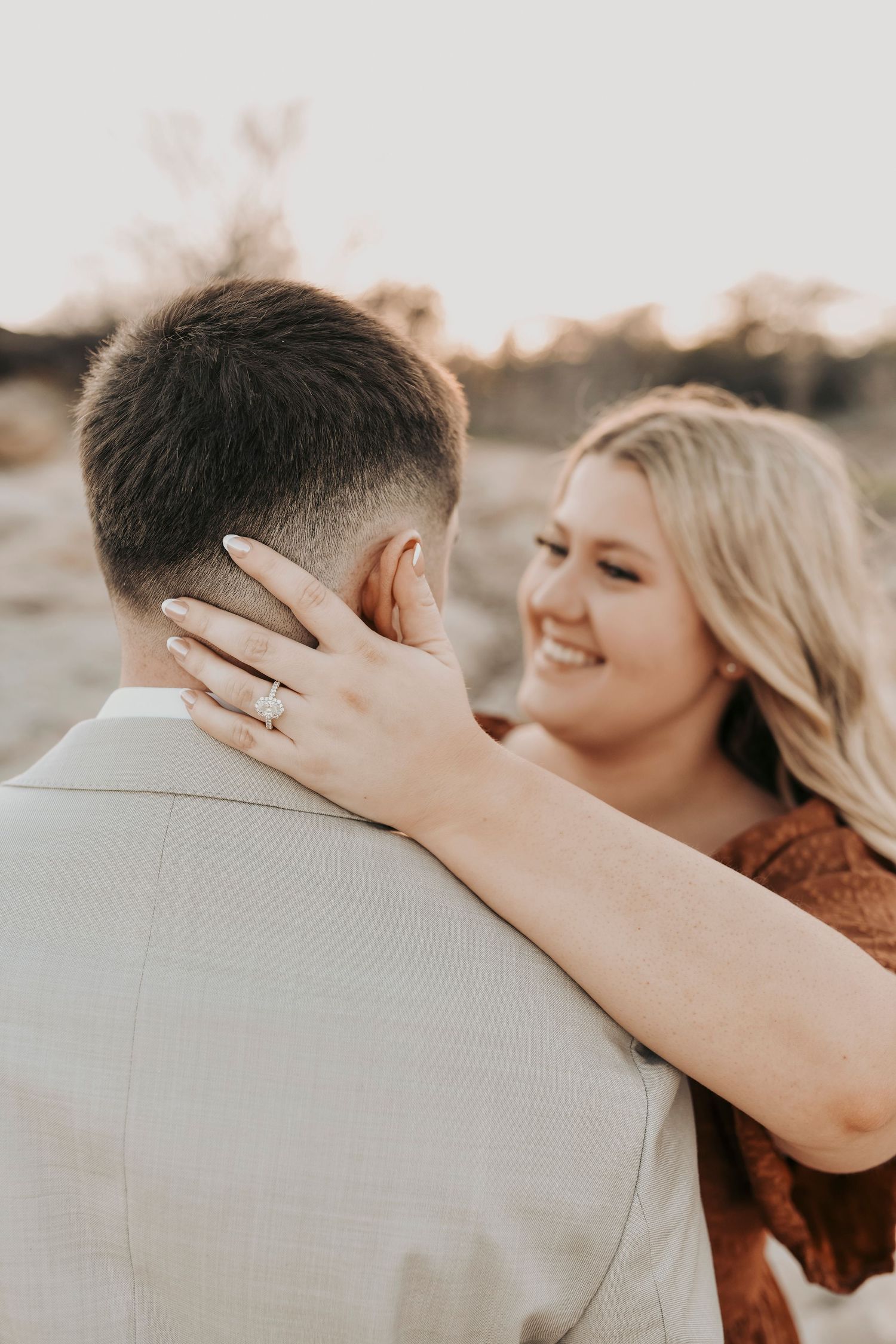 Engagement photos in scenic Texas field with sunset sky.
