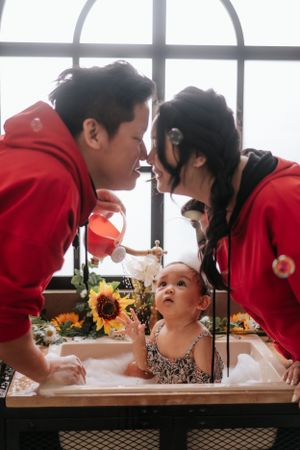 Photo session near large windows with sunflowers and bath time setup.在大窗戶旁拍攝向日葵和沐浴場景的照片。