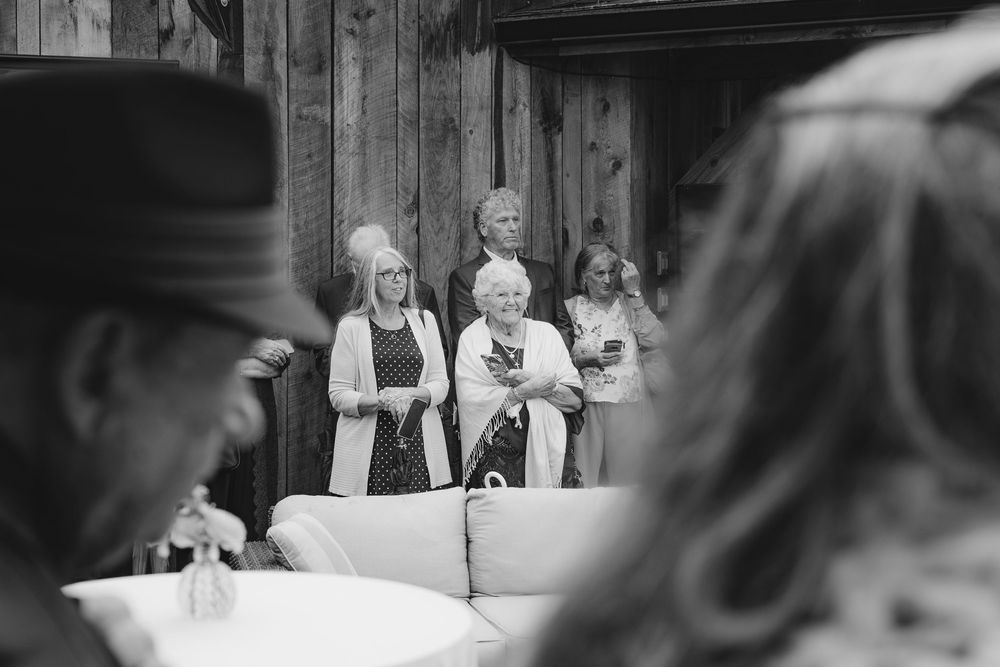 A black and white photo montage of a wedding ceremony showing multiple candid moments throughout the celebration.