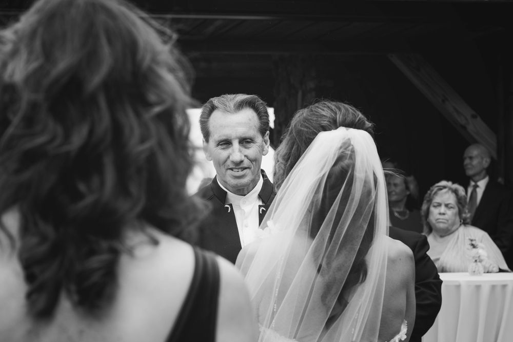 A black and white wedding photograph showing a couple sharing an intimate moment during their celebration.