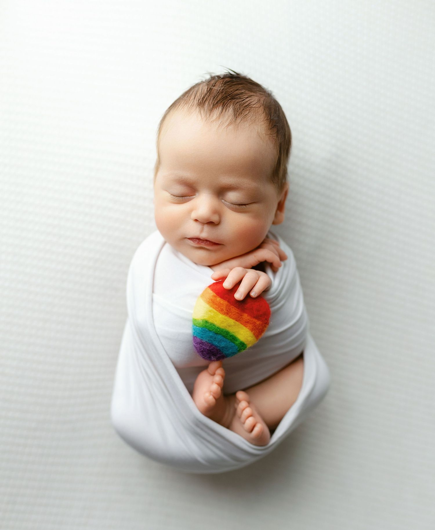 Newborn boy holding a rainbow heart. - Greenville, SC newborn photographer - Easley, SC newborn photographer.