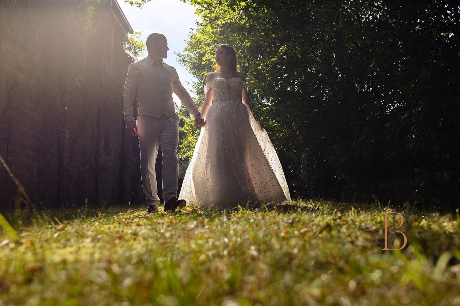 Bride and groom share a romantic moment on a wooden seat surrounded by lush greenery at Brockholes Nature Reserve, Preston. Jane Ball Photog