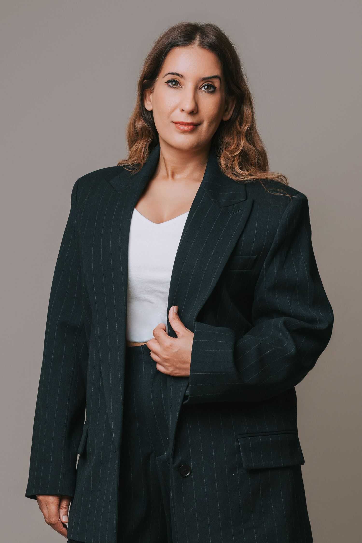 A model wearing a floral print blouse and black wide-leg pants poses in different angles against a gray backdrop.