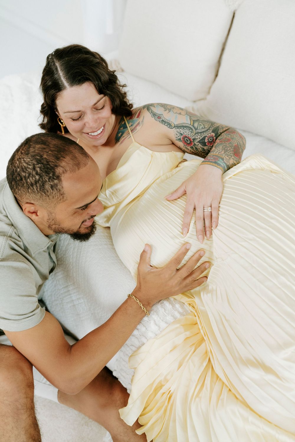 An intimate maternity moment captured with a couple in a light and airy setting.