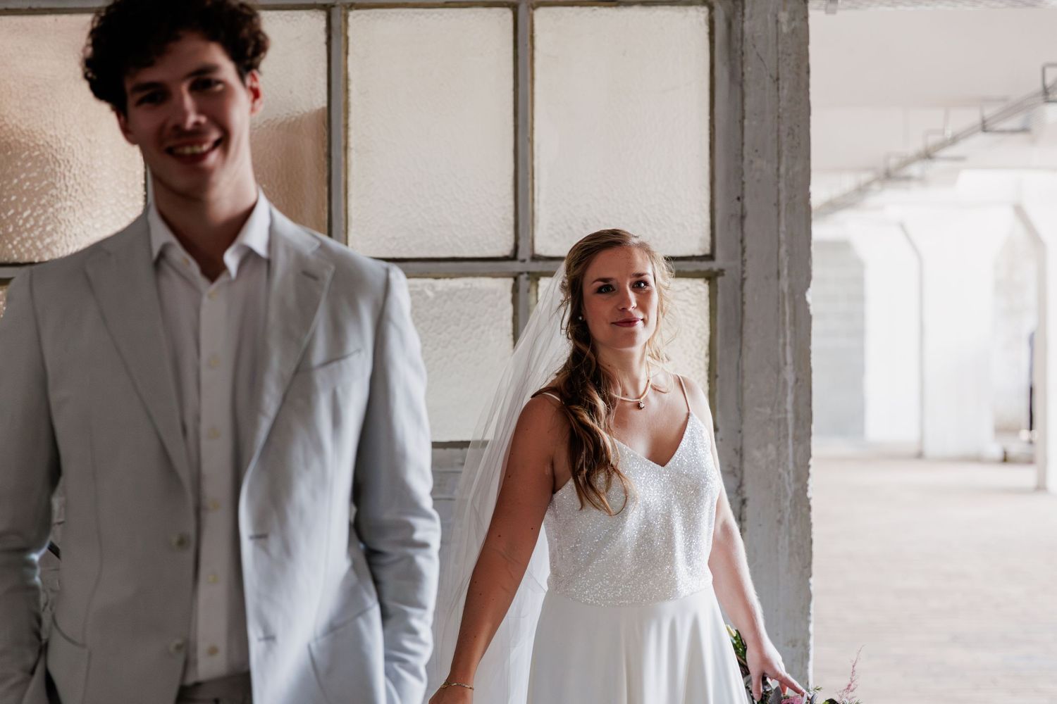 Modern industrial wedding venue with minimalist decor and large windows.
