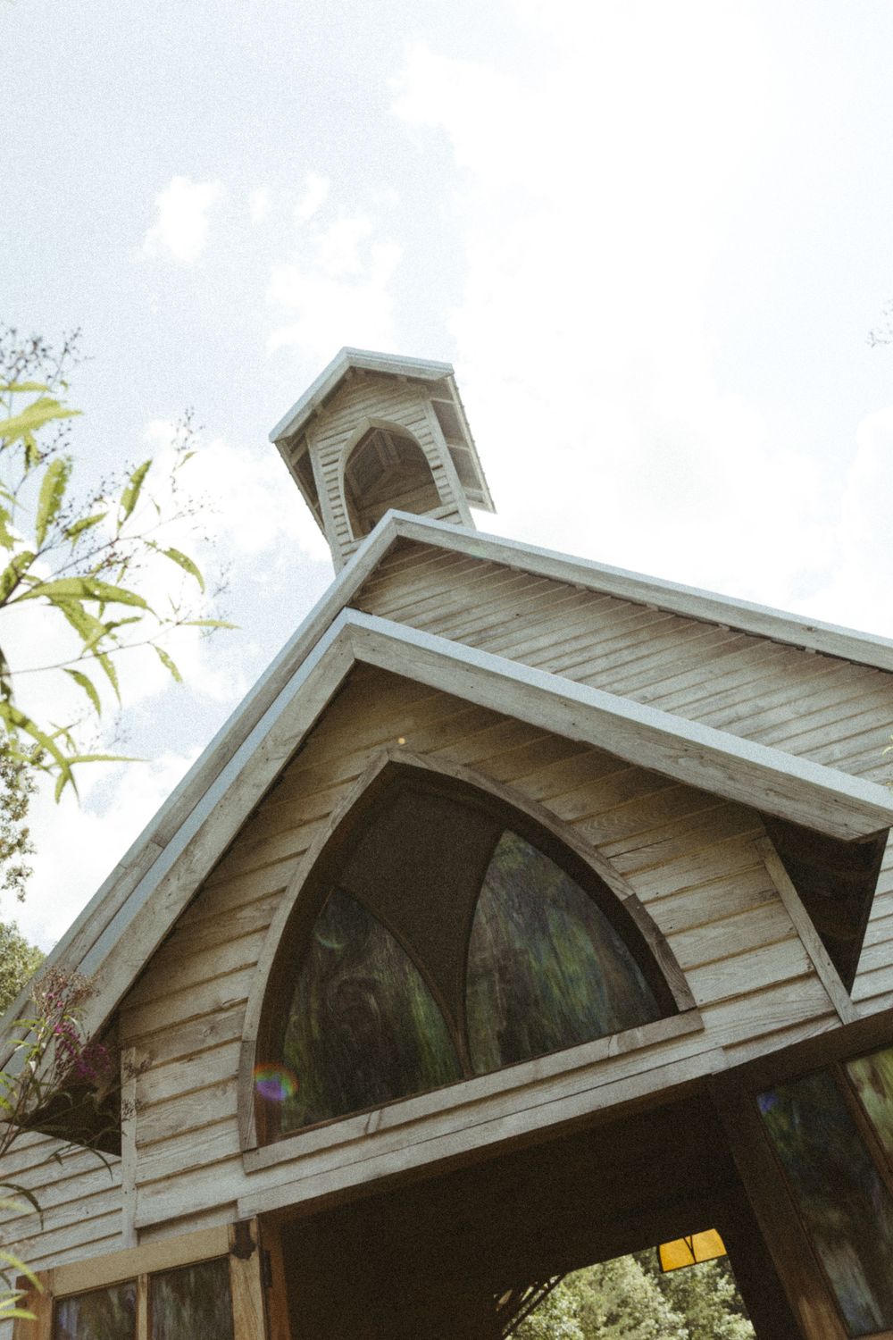 White wooden chapel entrance with arched doorway and architectural details.