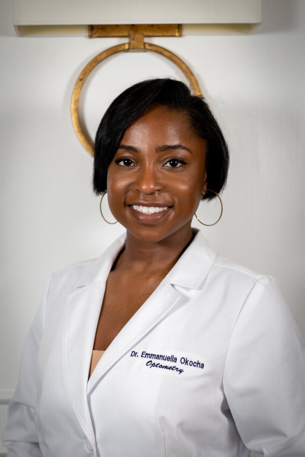 Medical professional in white coat smiling in studio portrait series.