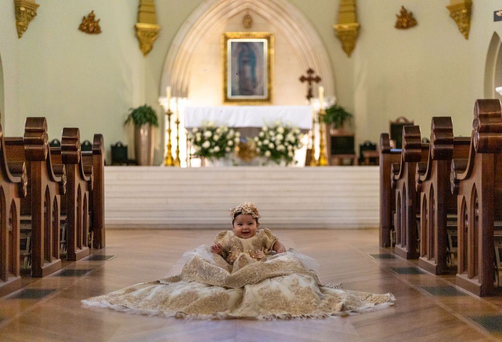 Baptism dress laid out beautifully along church aisle with ornate architectural details.