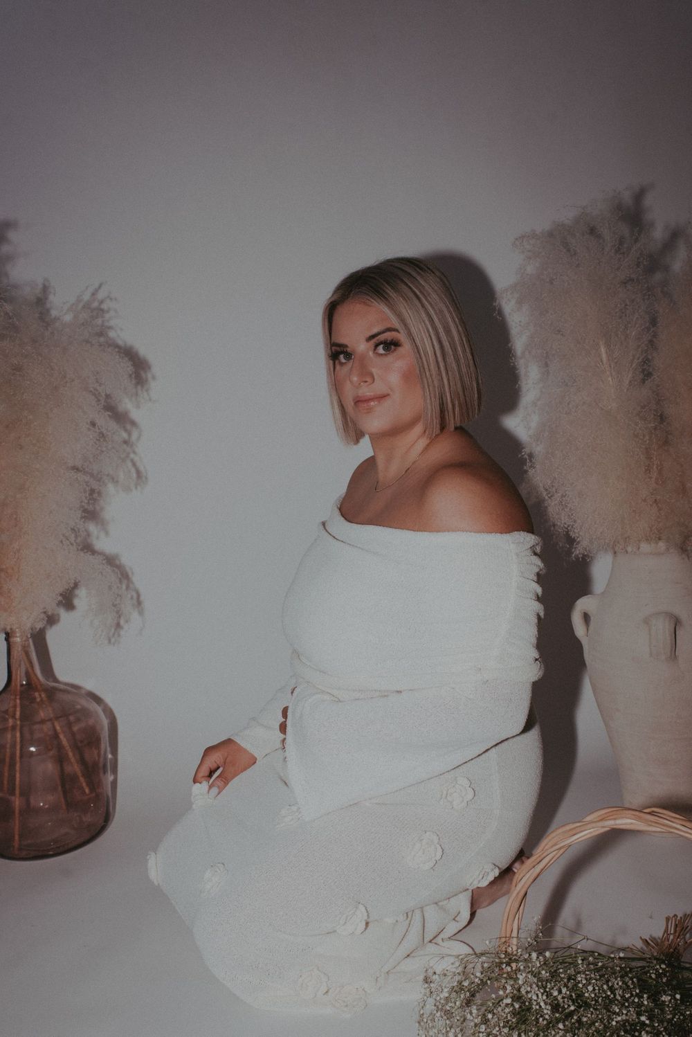 Person wearing a cozy white turtleneck sweater poses against a light background in a series of dreamy photos.