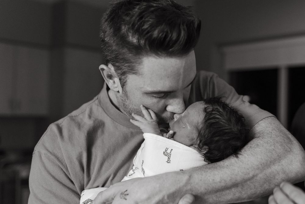 Black and white photo sequence shows couple kissing while embracing in what appears to be a candid romantic moment.