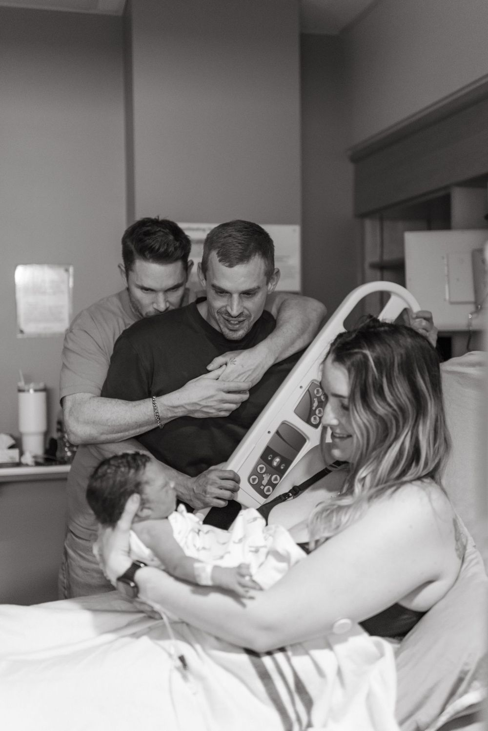 Black and white photos capture emotional moments during childbirth at hospital as parents welcome their newborn baby.