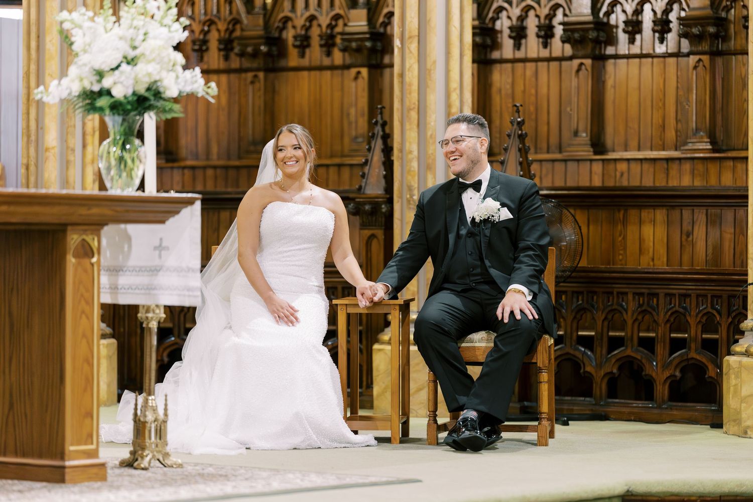 Wedding couple seated in ornate wooden church sanctuary between ceremony portraits showing various romantic poses.