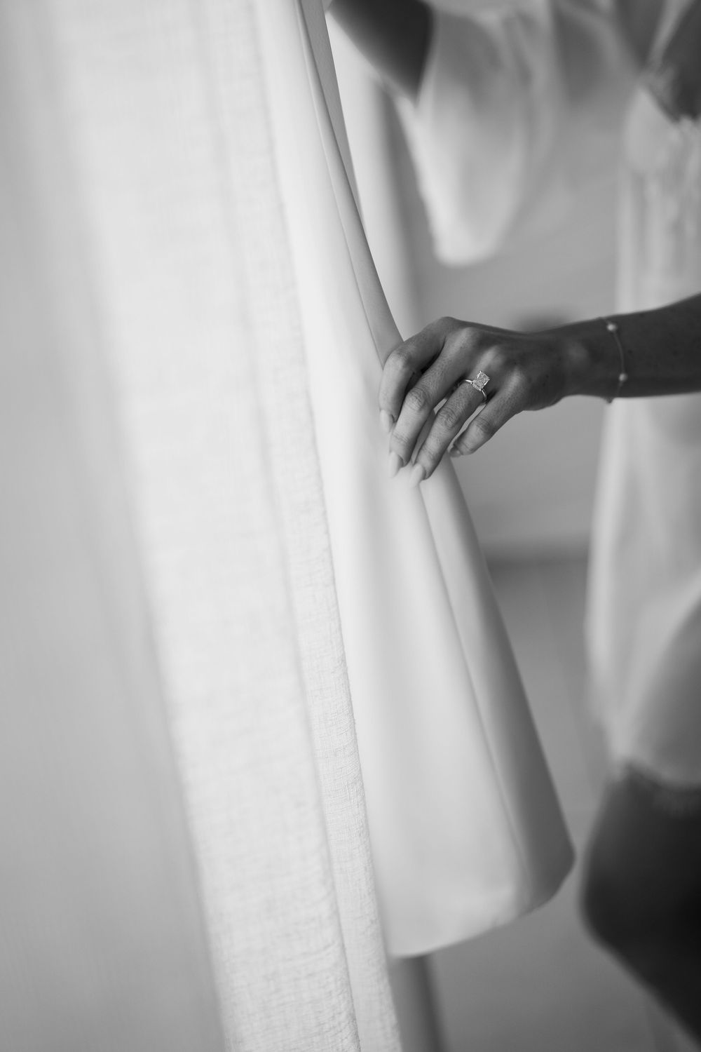 Close-up black and white shot of delicate lace details on a wedding dress.