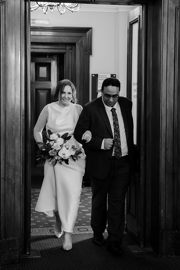 Black and white sequence of wedding photos showing a couple walking through an elegant hallway with dark wood paneling.