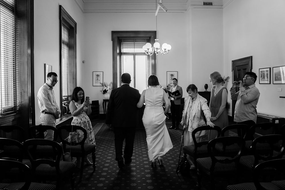 A series of black and white photos showing people gathered in what appears to be an indoor space.