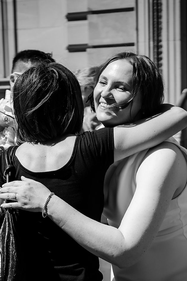 Black and white photos showing emotional embraces between wedding attendees.