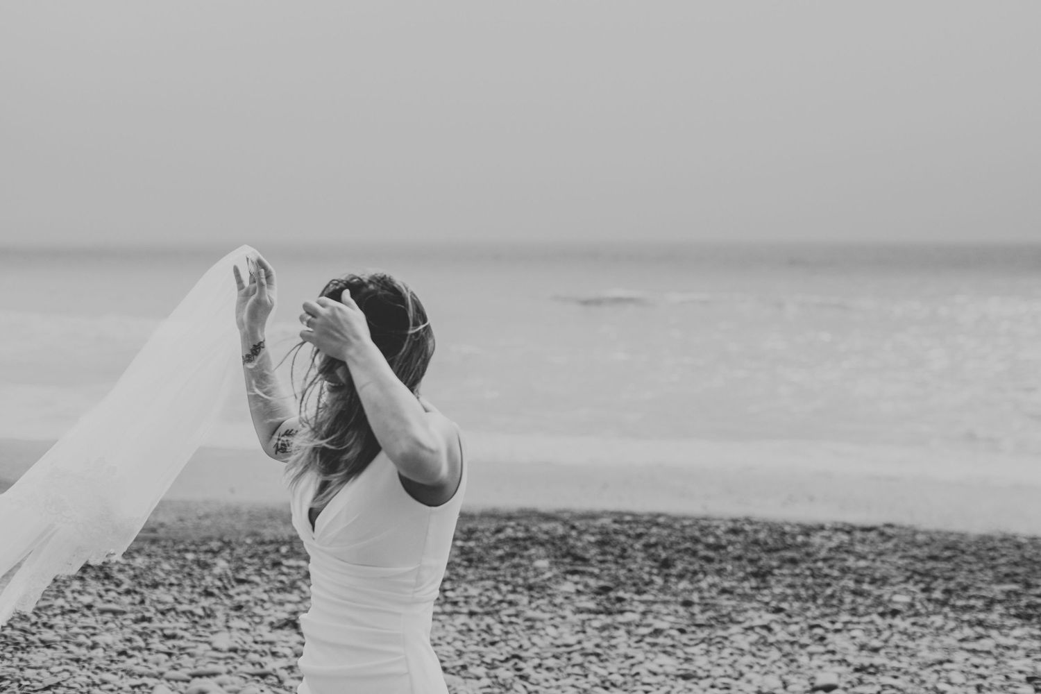 A panoramic black and white sequence of photos showing a couple posing and embracing on a beach.
