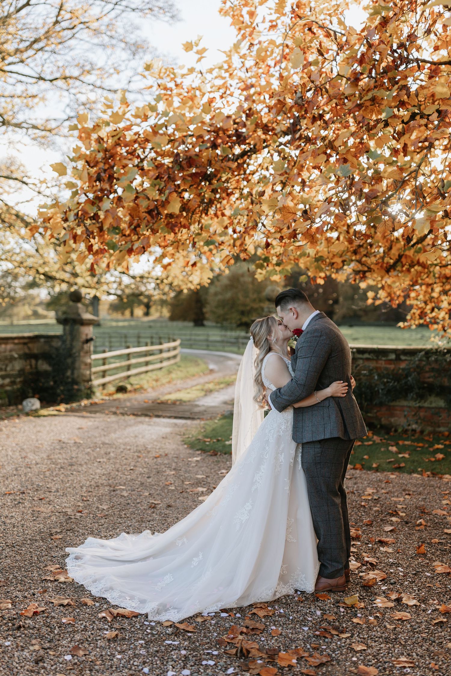 A romantic autumn wedding scene with a couple dancing surrounded by golden fall foliage.