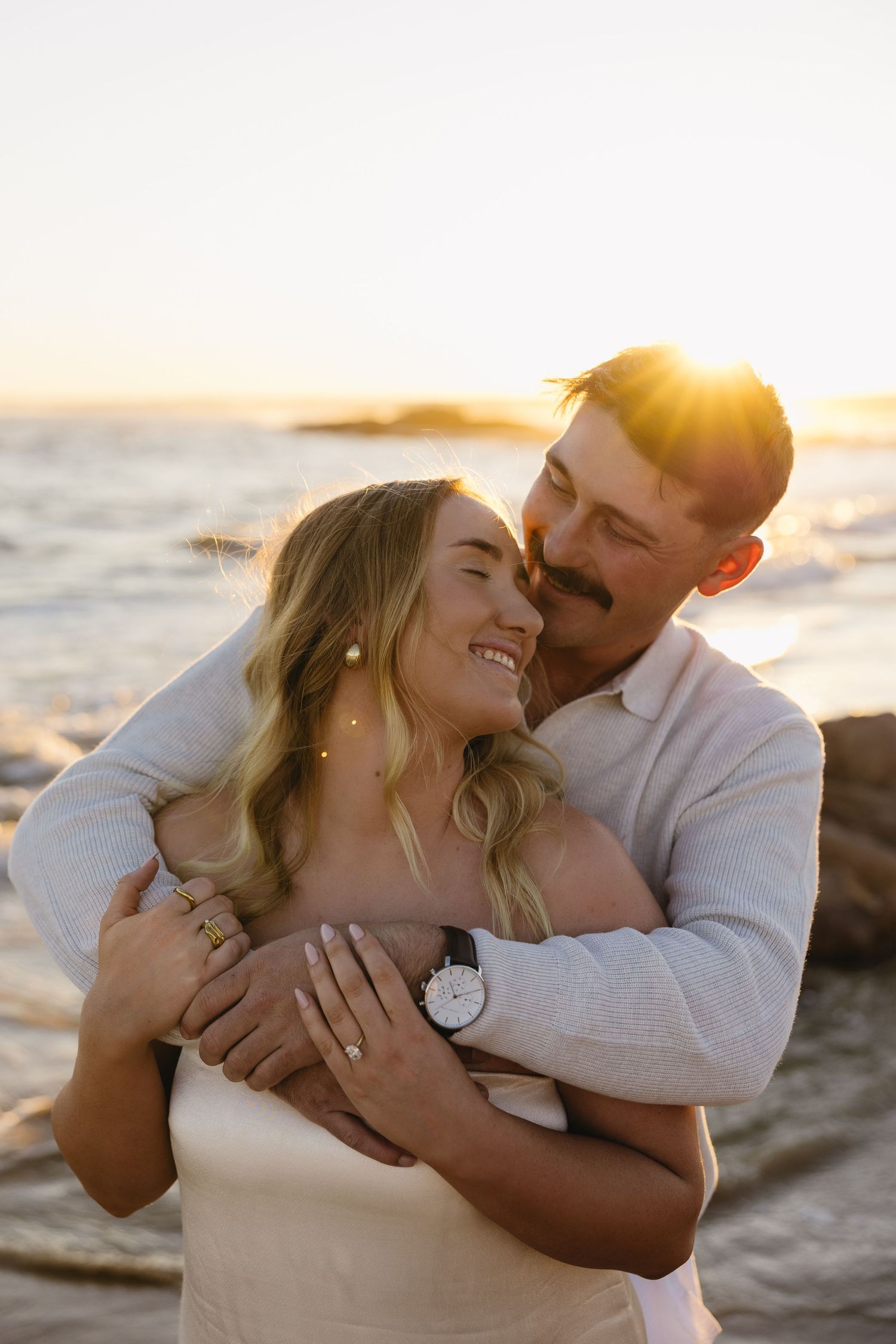 A couple shares tender moments on the beach at sunset in a series of romantic photographs.