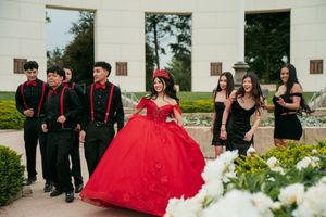 Formal event photography session in front of a white architectural backdrop with landscaping.