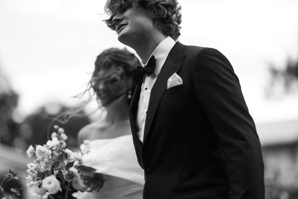 Black and white photo of newlyweds celebrating their special moment together in an outdoor setting.
