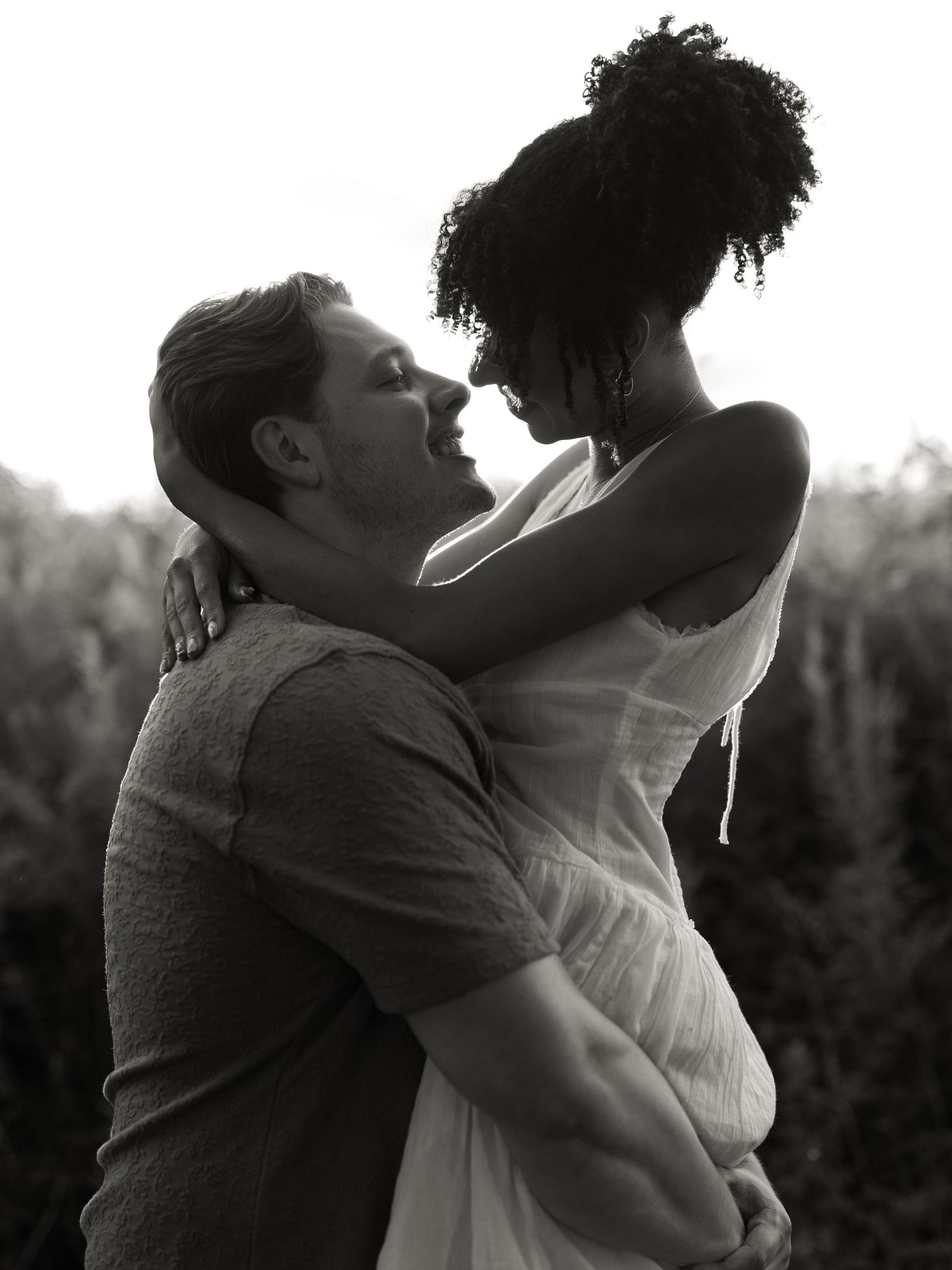 Black and white image series showing a loving embrace between two people in silhouette against a natural backdrop.