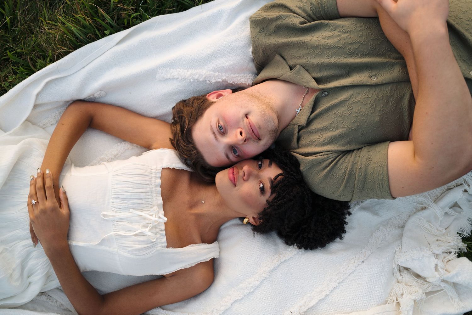 A collection of black and white portraits showing playful candid moments of laughter while lying down.