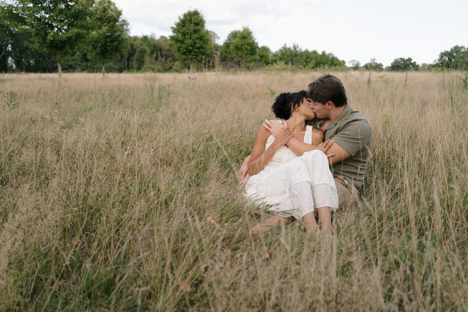 Romantic photoshoot in a golden field with tall grass during sunset.