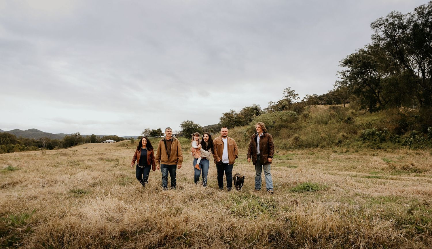 A group of individuals walking together through a golden grassy field on a bright autumn day.