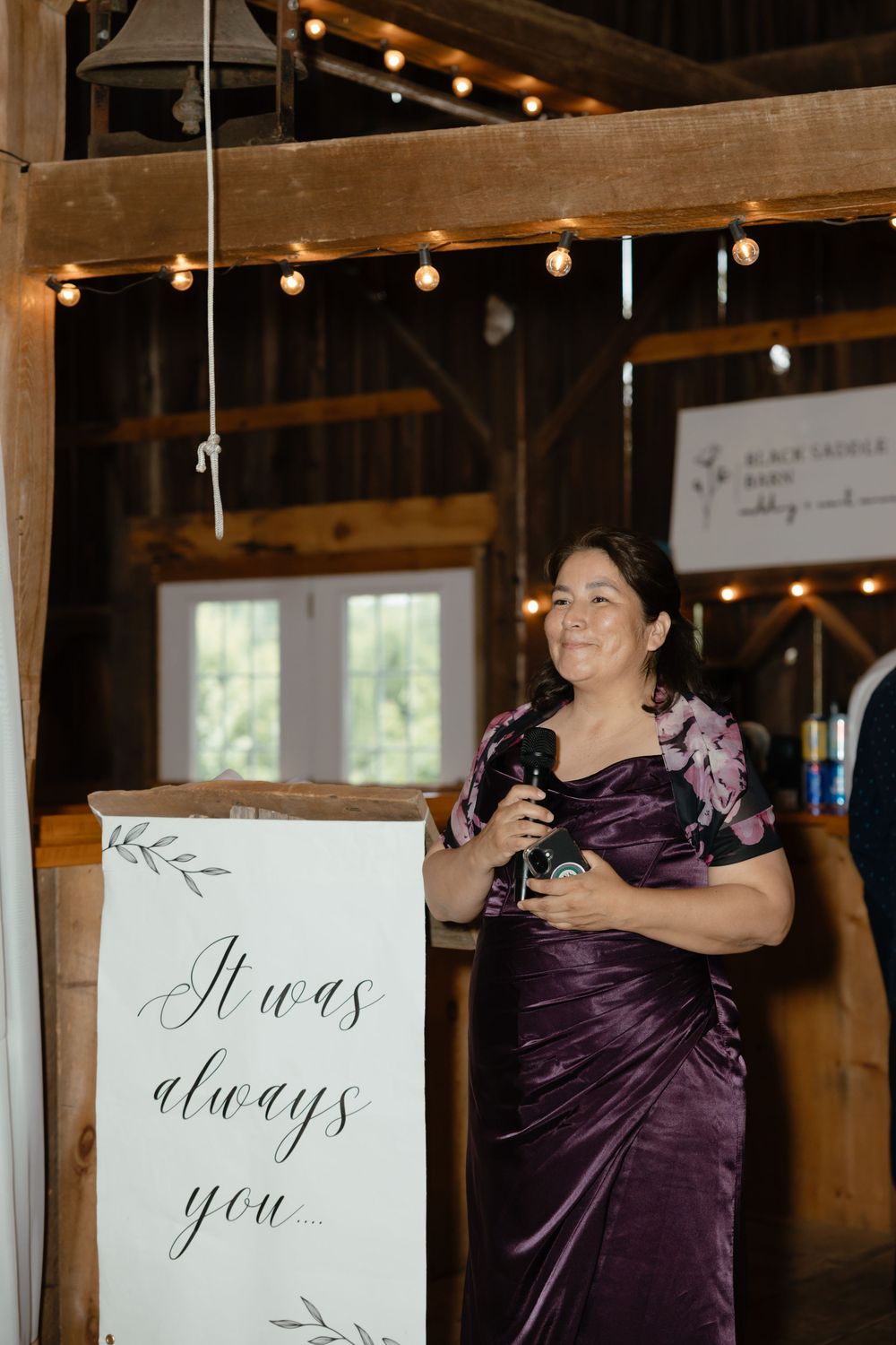 Wedding signage and decor featuring string lights and elegant calligraphy signs in a rustic barn venue.