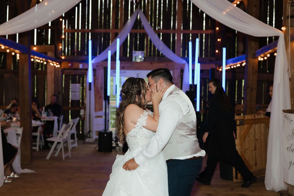 Wedding celebration venue decorated with white drapes and twinkling lights for evening festivities.