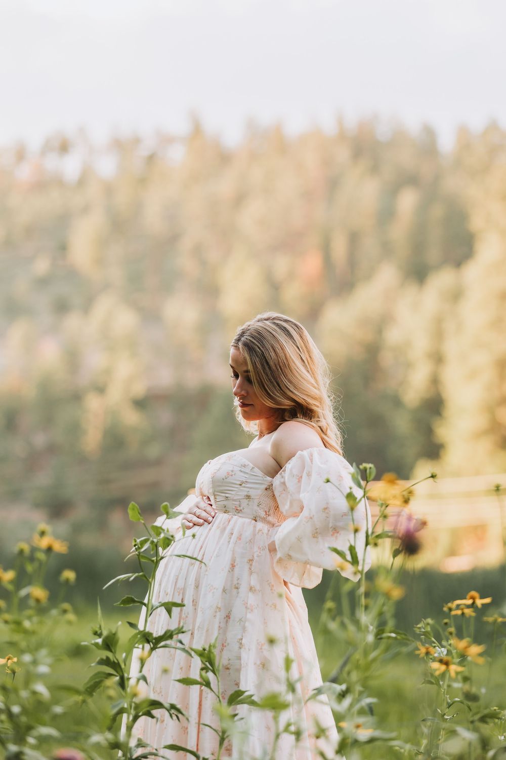 A person in a flowing white dress twirls gracefully through a golden sunlit meadow with blooming wildflowers.