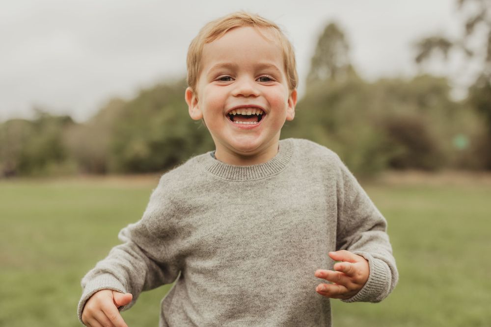 Joyful expressions during an outdoor photoshoot in a natural setting.