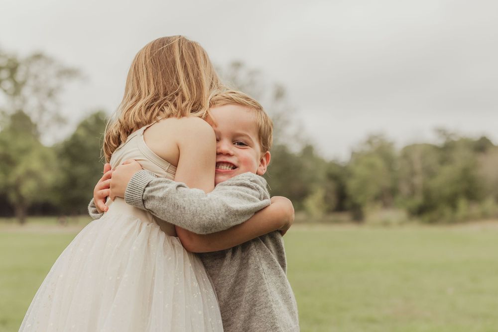 Sweet embraces and tender moments shared in a grassy field.