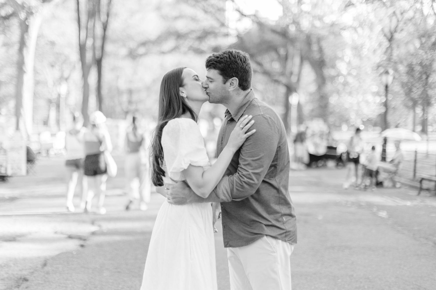 A couple stands in an intimate black and white moment outdoors during what appears to be an engagement photo session.