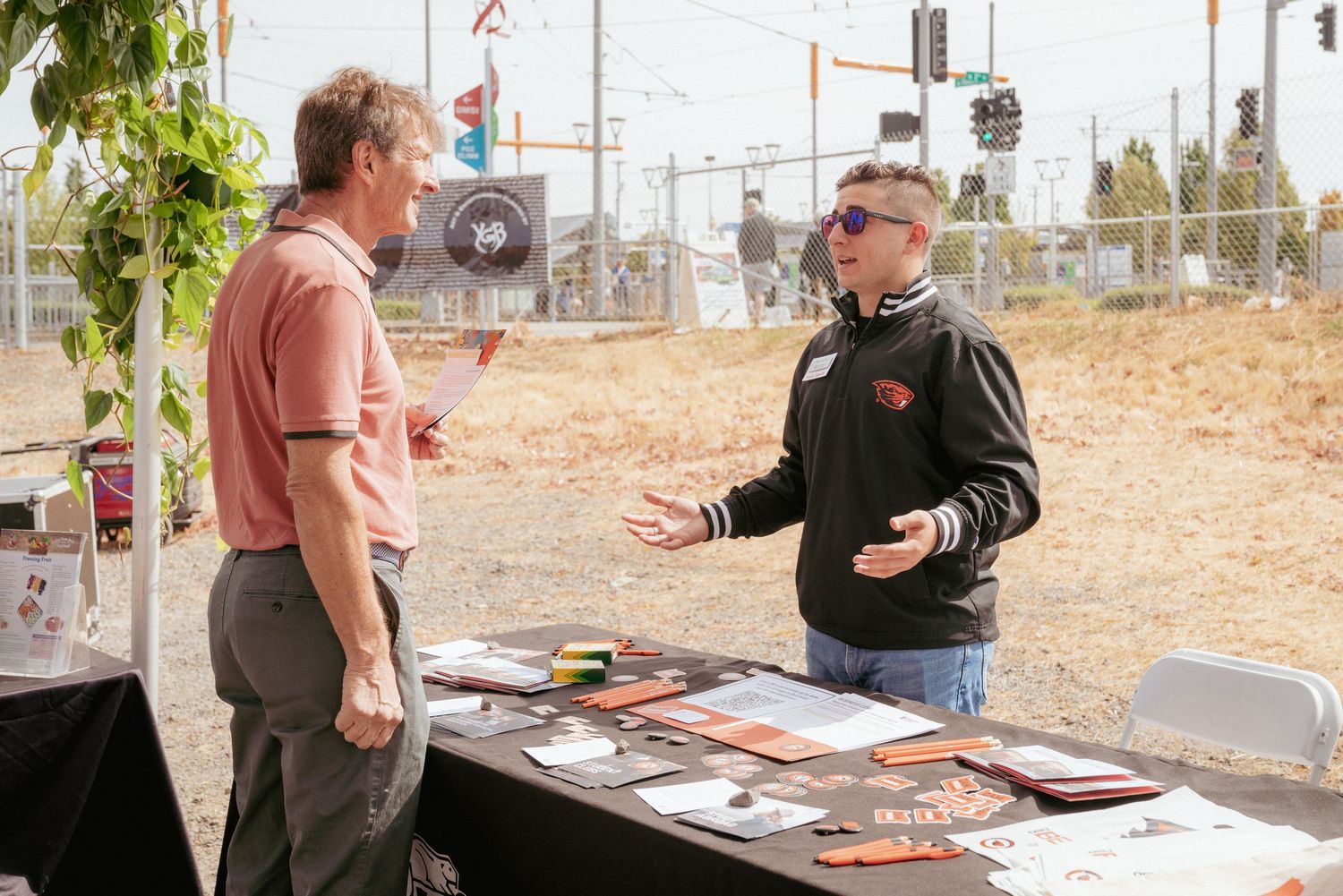 Two people talking at a branded booth during university outreach — brand & business photography, Vancouver WA.